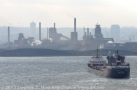 Algosteel has just entered the Burlington Bay - with a cargo of Iron Ore from the Labrador iron ore fields likely destined for Arcelor Mittal Dofasco (since US steel was not operating a blast furnace at the time of this photo). The ship is turning to dock at the Steel Mills of Hamilton (Dofasco) shown in the background.