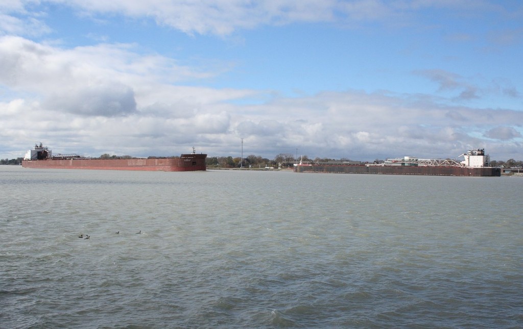 The 1004\' James R Barker, heading upriver, passes the smaller St. Clair on its namesake river at Sarnia, ON.